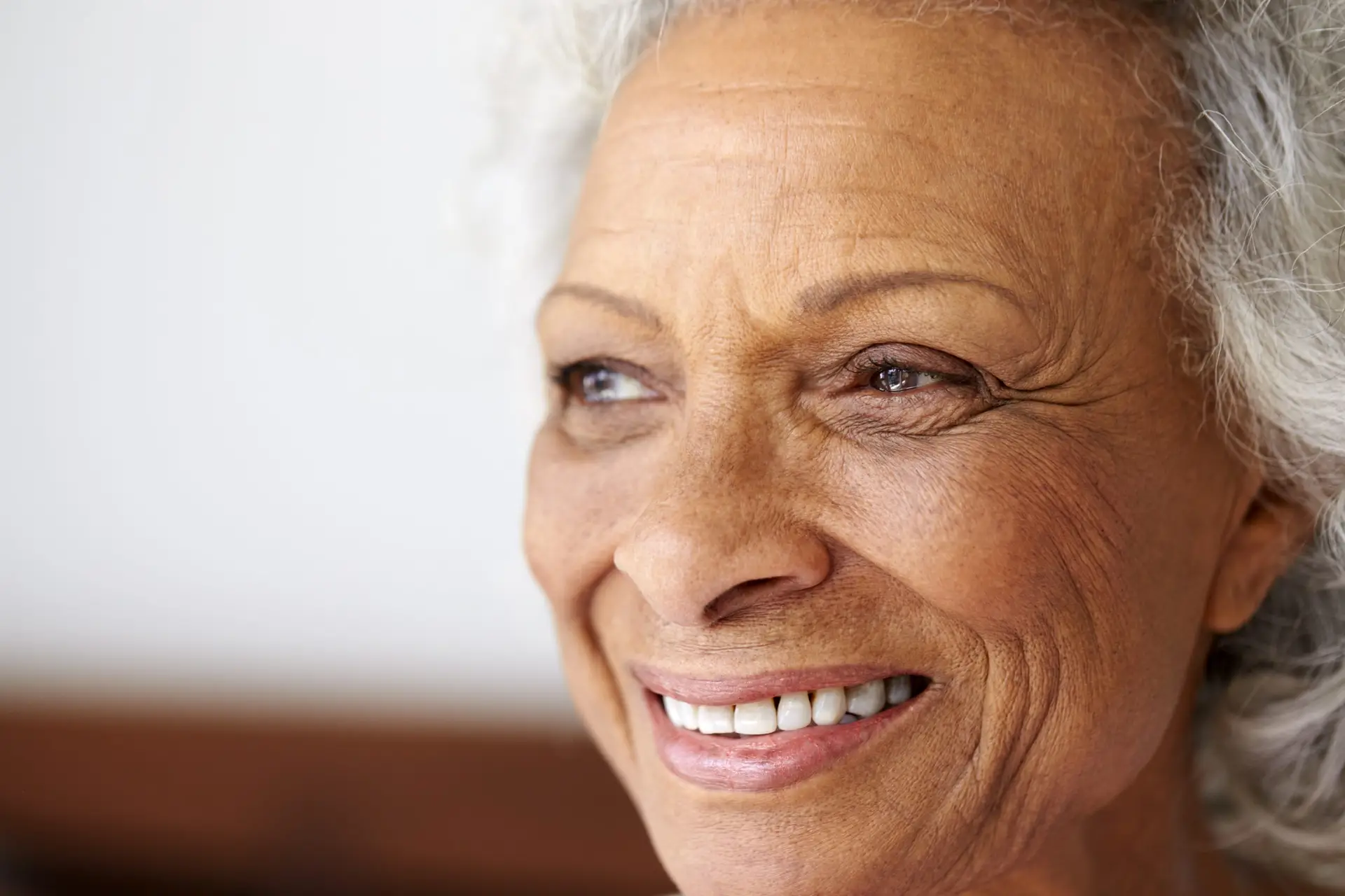 Close Up Of Smiling Senior Woman At Home Looking Positive